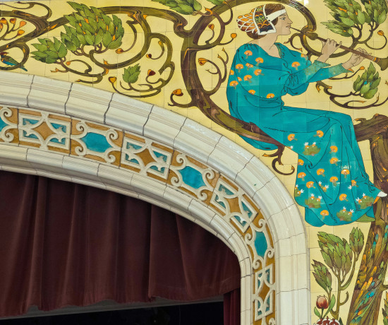 Detail from decorative proscenium arch at Jubilee Theatre Gosforth showing pre-Raphaelite female figure playing a musical instrument