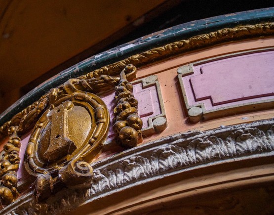 Red and gold detailed plasterwork on the front of a box within the auditorium of Burnley Empire