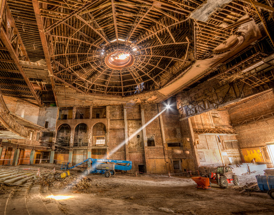 The shell of the auditorium of Bradford Odeon with a hole in the ceiling where the sunburned once was and a shaft of sunlight lighting up the interior. 
