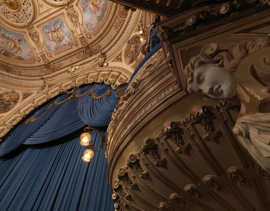Auditorium photo of Blackpool Grand, looking up at the detailing on one of the boxes and the proscenium. The sumptuous blue curtain is down.