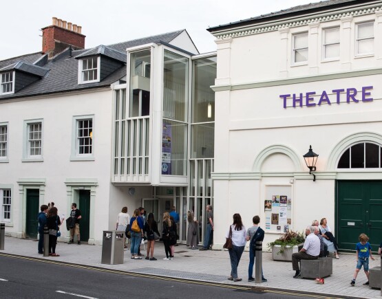 Exterior of Theatre Royal Dumfries with audienes wairting outside.