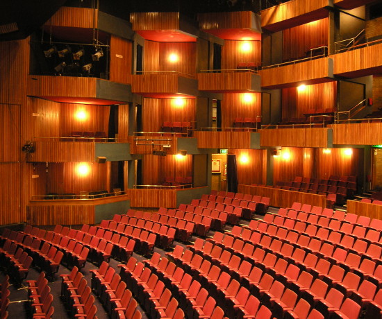 Billingham Forum auditorium with rows of red seats and wood panelled boxes and balconies