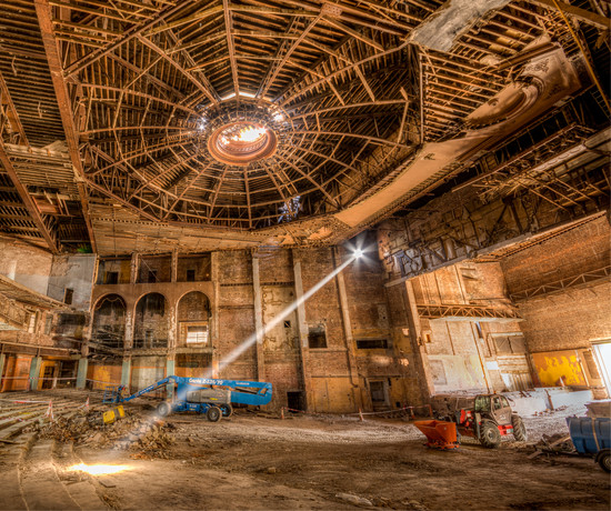 The shell of the auditorium of Bradford Odeon with a hole in the ceiling where the sunburned once was and a shaft of sunlight lighting up the interior. 