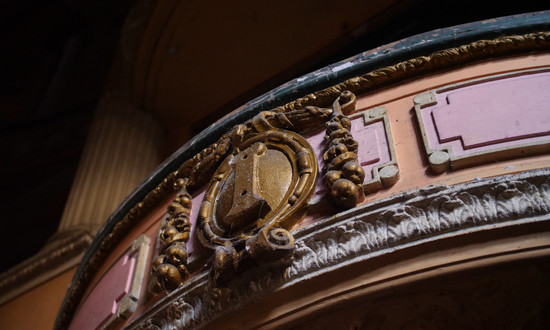 Up close balcony front plasterwork in the Classical style at Burnley Empire, with gold and red detailing