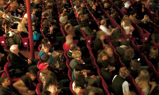 Full audience in theatre auditorium.