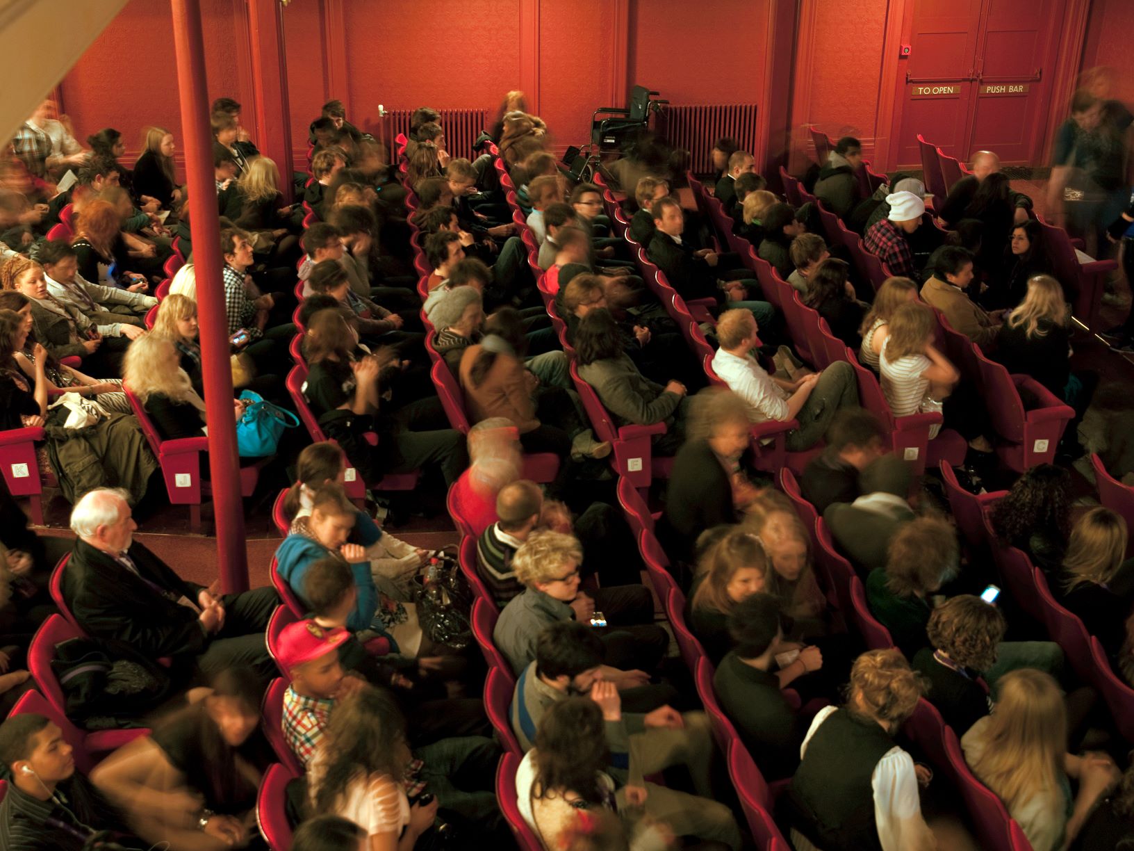 Full audience in theatre auditorium.