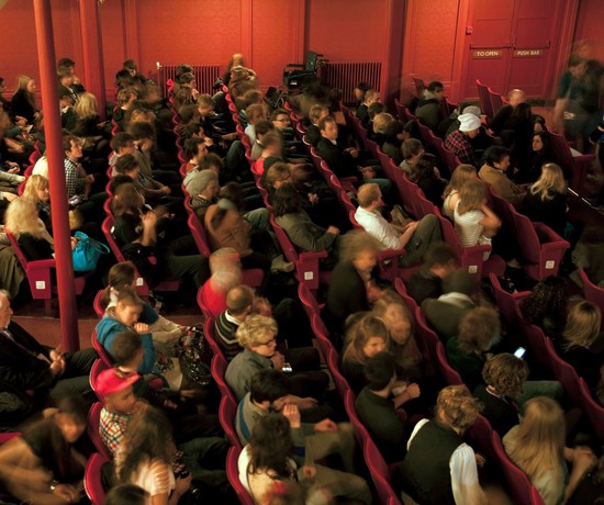 Full audience in theatre auditorium.