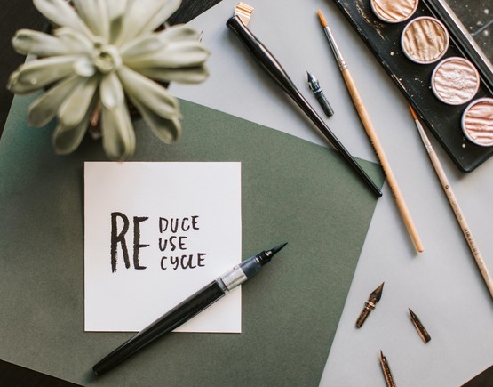 Reduce Reuse Recycle on a note with art materials