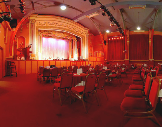 Auditorium of small theatre with seating laid out in caberet style
