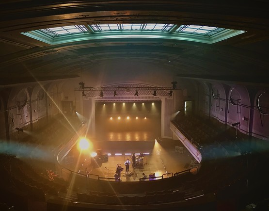 Darkened auditorium of Leith Theatre from the back of the single balcony overlooking the flat-floored stalls and to the stage