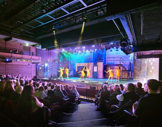 A dance performance taking place with a full audience in the main space at The Malthouse theatre.