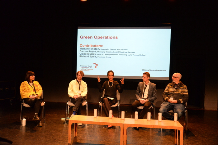 Panel discussion at Conference 21 with five participants in front of a presentation screen 