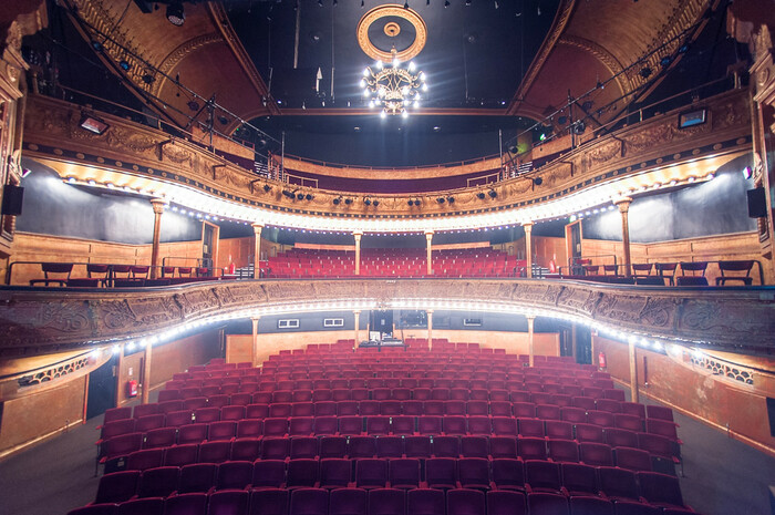 Historic theatre auditorium of the Citizens Theatre, viewed from the stage showing seating in stalls and dress circle with ornate plasterwork.