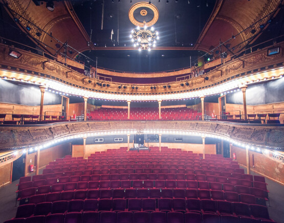Historic theatre auditorium of the Citizens Theatre, viewed from the stage showing seating in stalls and dress circle with ornate plasterwork.