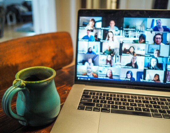 Laptop screen with online meeting with multiple participants