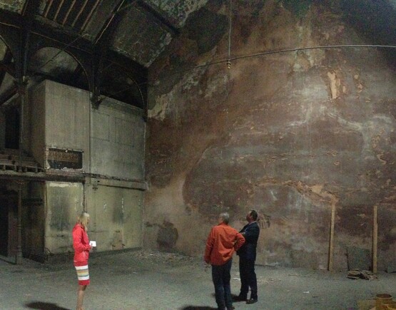 Three people inside a derelict theatre