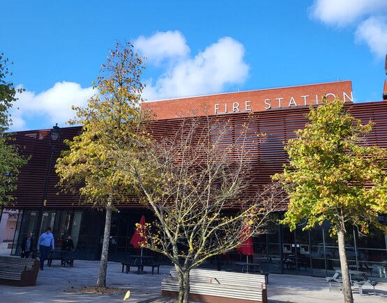 The exterior of the Fire Station Auditorium facing onto the public square on a sunny day. 