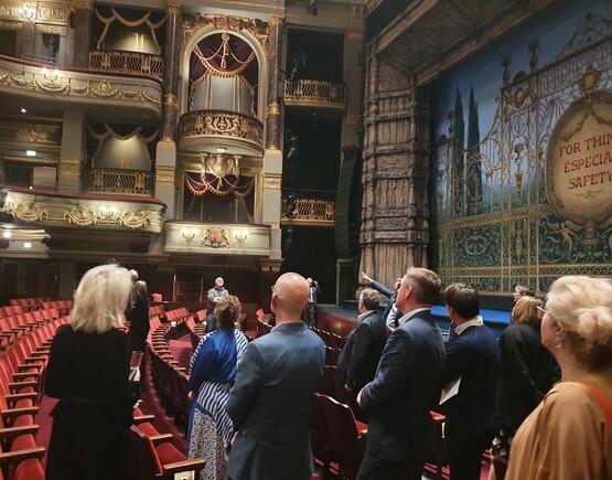Group of people on a tour of a historic theatre auditorium.