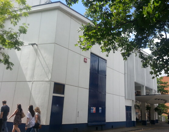 Exterior of Yvonne Arnaud Theatre, a large white building with a canopy over the entrance.