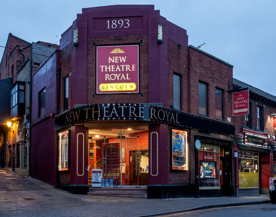 Corner site entrance to the New Theatre Royal in Lincoln at dusk.