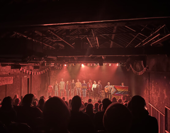 Performance of The Regulars at Hope Mill Theatre in front of a busy audience in the small theatre auditorium.