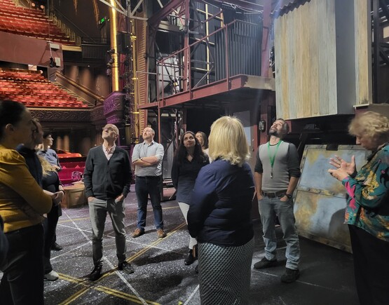 Group of people on stage having a tour of a theatre.