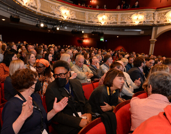 Audience at a conference in a historic theatre auditorium.