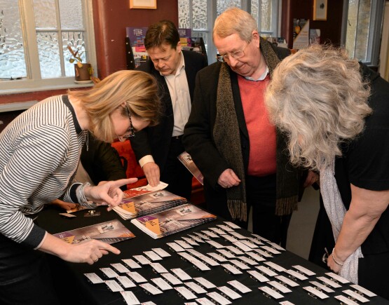 People collecting their name pages at an event.