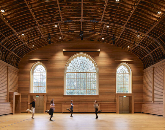 Interior of historic theatre space with a domed ceiling and performers on the flat floor