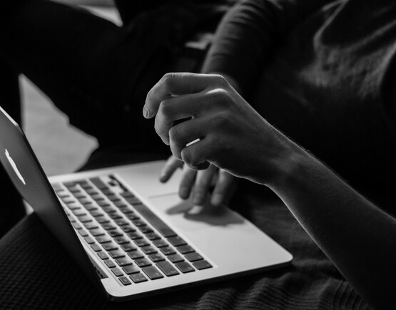 Hands hovering over a laptop