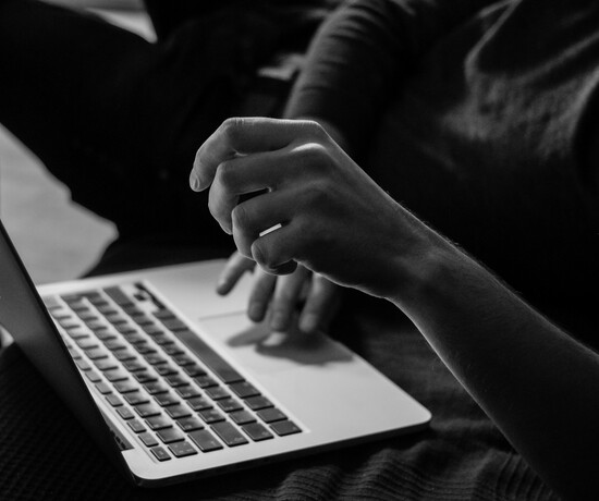 Hands hovering over a laptop