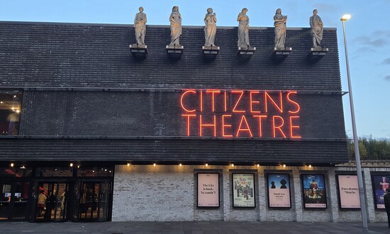 Exterior of Citizens Theatre with six figure on the roof