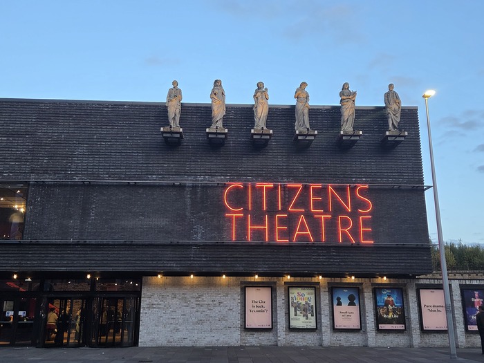 Exterior of Citizens Theatre with six figure on the roof