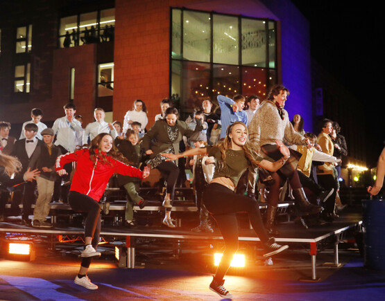 Group of young performers dancing outside of a building